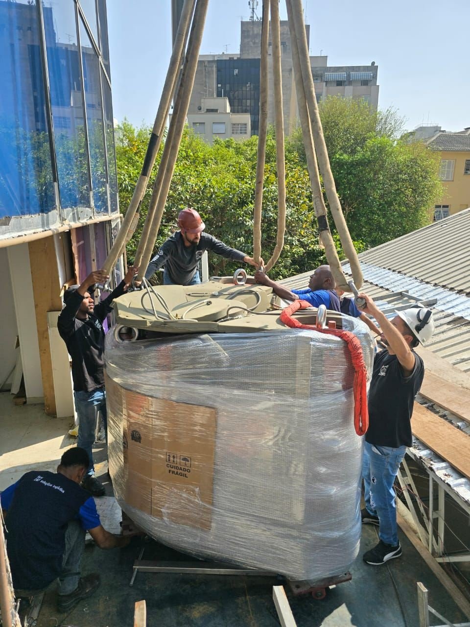 Equipe da Slift içando equipamento embalado sobre telhado
