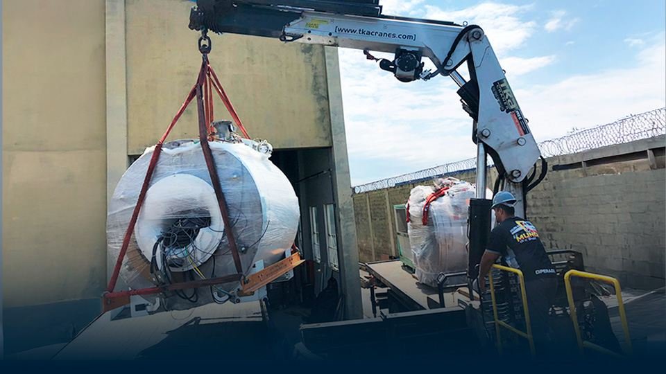 Ressonância magnética embalada sendo içada por guindaste